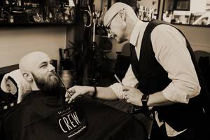 A traditional beard trimming with scissors